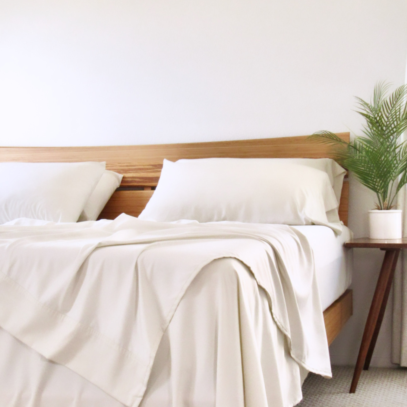 Natural bamboo bedding with copper infusion, soft cream pillowcase set on a wooden headboard.
